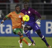 Rainford Kalaba of Zambia (L) challenges goalkeeper Bouna Coundoul of Senegal during the African Nations Cup soccer tournament in Estadio de Bata "Bata Stadium", in Bata, January 21, 2012. PHOTO BY REUTERS/Amr Abdallah Dalsh