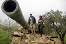 Rebel fighters from Suqour al-Sham Brigade stank on a tank during clashes with forces loyal to Syria's president Bashar al-Assad as they flee Idlib city, after rebel fighters took control of the area, on Al-Mastumah hill, March 28, 2015. PHOTO BY REUTERS/Mohamad Bayoush