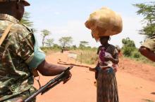 A South Sudanese refugee woman carries her child and belongings as she talks to a Uganda People's Defence Forces (UPDF) soldier after crossing into Uganda at the Ngomoromo border post in Lamwo district, northern Uganda, April 4, 2017. PHOTO BY REUTERS/Stringer