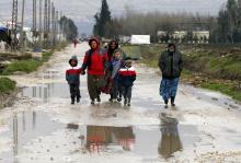 Syrian refugees walk along a makeshift settlement in Bar Elias in the Bekaa valley, January 5, 2015. PHOTO BY REUTERS/Mohamed Azakir