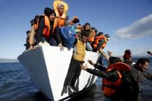 Refugees and migrants jump off a boat as they arrive on the Greek island of Lesbos, in this November 26, 2015 file photo. TPHOTO BY REUTERS/Giorgos Moutafis