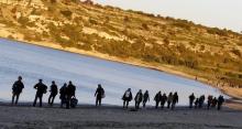 Refugees walk along a beach before trying to travel to the Greek island of Chios from the western Turkish coastal town of Cesme, in Izmir province, Turkey, March 5, 2016. REUTERS/Umit Bektas