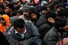 Refugees and migrants wait to be transferred to the Moria registration centre after arriving at the port of Mytilene on the Greek island of Lesbos, following a rescue operation by the Greek Coast Guard at open sea, March 22, 2016. PHOTO BY REUTERS/Alkis Konstantinidis