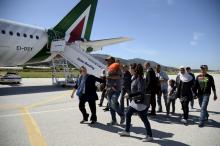 A group of Syrian refugees arrive to board a plane with Pope Francis at the airport of Mytilene, in the Greek island of Lesbos, April 16, 2016. PHOTO BY REUTERS/Filippo Monteforte