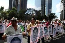Relatives carry photos of some of the 43 missing students of the Ayotzinapa teachers' training college during a march to mark the ten-month anniversary of their disappearance, in Mexico City, Mexico, July 26, 2015. PHOTO BY REUTERS/Stringer