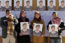 Relatives of Islamic State captive Jordanian pilot Muath al-Kasaesbeh hold pictures of him as they join students during a rally calling for his release, at Jordan University in Amman, February 3, 2015. PHOTO BY REUTERS/Muhammad Hamed