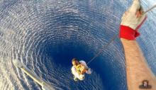 A migrant is rescued by an Italian Navy helicopter in the area where his boat sank in the Mediterranean Sea, August 11, 2015. PHOTO BY REUTERS/Italian Navy