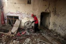 A rescue worker sifts through the rubble after a suicide bomber blew himself up close to a police checkpoint in Peshawar, Pakistan, January 19, 2016. PHOTO BY REUTERS/Fayaz Aziz