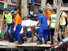 Rescuers carry a body recovered from a capsized boat believed to be carrying illegal migrants, at a jetty in Hutan Melintang, near Teluk Intan, Malaysia, September 3, 2015. PHOTO BY REUTERS/The New Straits Times Press