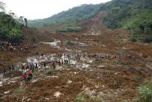 Indonesian soldiers and rescue team members walk through the mud after a landslide hit the village of Sampang in Banjarnegara, December 13, 2014. REUTERS/Idhad Zakaria