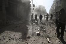 Residents inspect damage after what activists said was an airstrike by forces loyal to Syria's President Bashar al-Assad on the town of Douma, eastern Ghouta of Damascus, September 19, 2015. PHOTO BY REUTERS/Bassam Khabieh