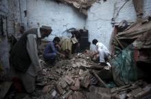 Residents search for belongings in the rubbles of a house after it was damaged by an earthquake in Peshawar, Pakistan, October 26, 2015. PHOTO BY REUTERS/Fayaz Aziz 
