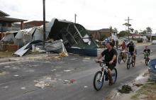 Residents from Sydney's southern suburb of Kurnell assess the damage from a houses's roof which had blown down the street following a rare tornado, December 16, 2015. PHOTO BY REUTERS/Jason Reed