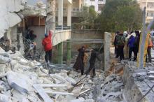 A man helps a woman making her way through the rubble of a damaged building after what activists said were airstrikes carried out by the Russian air force in Idlib city, Syria, December 20, 2015. PHOTO BY REUTERS/Ammar Abdullah