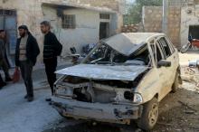 Residents stand near a damaged car in the town of Darat Izza, province of Aleppo, Syria, February 28, 2016. PHOTO BY REUTERS/Ammar Abdullah