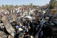 Residents gather at the site of a bomb attack at a checkpoint in the city of Hilla, south of Baghdad, March 6, 2016. REUTERS/Alaa Al-Marjani