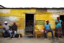 Members of a mining community sit outside their shacks in Nkaneng township, Marikana's informal settlement, in Rustenburg, April 1, 2014. PHOTO BY REUTERS/Siphiwe Sibeko