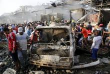 Residents gather at the site of a truck bomb attack at a crowded market in Baghdad, August 13,2015. PHOTO BY REUTERS/Wissm Al- Okili