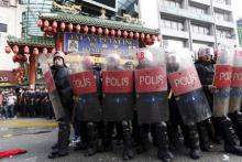 Riot police protect the entrance to Chinatown from "Red Shirt" demonstrators during a rally to celebrate Malaysia Day and to counter a massive protest held over two days last month that called for Prime Minister Najib Razak's resignation over a graft scandal, in Kuala Lumpur, Malaysia, September 16, 2015. PHOTO BY REUTERS/Olivia Harris