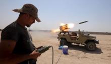 Members of Iraq's Shi'ite paramilitaries launch a rocket toward Islamic State militants outskirt the city of Falluja in province of Anbar, Iraq, July 12, 2015. PHOTO BY REUTERS/Stringer