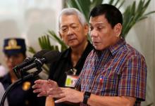 Philippine President Rodrigo Duterte speaks next to Foreign Affairs Secretary Perfecto Yasay, before Filipino workers who were repatriated by the Philippine government from Saudi Arabia, upon their arrival at the Ninoy Aquino International Airport in Manila, Philippines, August 31, 2016. PHOTO BY REUTERS/Erik De Castro