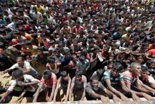 Rohingya refugees react as aid is distributed in Cox's Bazar, Bangladesh, September 21, 2017. PHOTO BY REUTERS/Cathal McNaughton