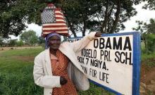 Rosa Anyango poses for a photograph as she carries a bag with the colors of the U.S. flag as she walks from the market near the ancestral home of U.S. President Barack Obama in Nyangoma village in Kogelo, west of Kenya's capital Nairobi, June 22, 2015. PHOTO BY REUTERS/Thomas Mukoya