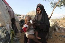 Rukia Nur feeds her child outside her makeshift dwelling after fleeing famine in the Marka Lower Shebbele regions to the capital Mogadishu, September 20, 2014. PHOTO BY REUTERS/Feisal Omar