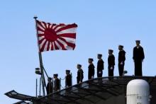 Sailors stand on the deck of the Izumo warship as it departs from the harbour of the Japan United Marine shipyard in Yokohama, south of Tokyo, March 25, 2015. PHOTO BY REUTERS/Thomas Peter