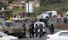 Israeli security forces gather near the scene of what the Israeli military said were back-to-back gun and car-ramming attacks by Palestinians, near the Jewish settlement of Kiryat Arba near the West Bank city of Hebron, March 14, 2016. PHOTO BY REUTERS/Mussa Qawasma