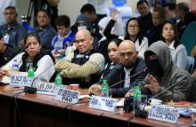 A witness to a recent teen killing linked to illegal drugs, wearing a sweatshirt and mask to hide his identity gestures while parents of the killed teenager, wearing bulletproof vests listen during the Senate investigation on illegal drugs at the Senate headquarters in Pasay city, metro Manila, Philippines October 2, 2017. PHOTO BY REUTERS/Romeo Ranoco