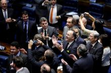 Members of Brazil's Senate react after a vote to impeach President Dilma Rousseff for breaking budget laws in Brasilia, Brazil, May 12, 2016. PHOTO BY REUTERS/Ueslei Marcelino