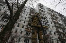 A pro-Russian separatist stands guard in front of a building damaged during fighting between pro-Russian rebels and Ukrainian government forces near Donetsk Sergey Prokofiev International Airport, eastern Ukraine, December 16, 2014. PHOTO BY REUTERS/Maxim Shemetov