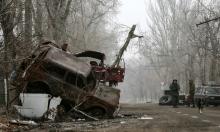 Pro-Russian separatists stand guard next to cars damaged during fighting between pro-Russian rebels and Ukrainian government forces near Donetsk Sergey Prokofiev International Airport, eastern Ukraine, December 16, 2014. PHOTO BY REUTERS/Maxim Shemetov