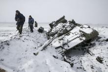 Members of the separatist self-proclaimed Donetsk People's Republic army collect parts of a destroyed Ukrainian army tank in the town of Vuhlehirsk, about 10 km (6 miles) to the west of Debaltseve, February 16, 2015. PHOTO BY REUTERS/Baz Ratner