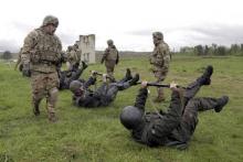 Servicemen of the U.S. Army's 173rd Airborne Brigade Combat Team (standing) train members of the Ukrainian National Guard during a joint military exercise called "Fearless Guardian 2015" at the International Peacekeeping and Security Center near the western village of Starychy, Ukraine, May 7, 2015. PHOTO BY REUTERS/Roman Baluk