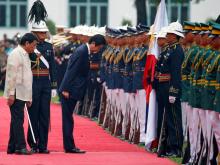 Japanese Prime Minister Shinzo Abe bows his head before the Philippine flag during a welcome ceremony at the presidential palace in Manila, Philippines, January 12, 2017. PHOTO BY REUTERS/Erik De Castro