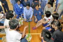 Japan's Prime Minister Shinzo Abe (top C) talks with evacuees from an area flooded by the Kinugawa river, caused by typhoon Etau, at an evacuation center in Joso, Ibaraki prefecture, Japan, September 12, 2015. PHOTO BY REUTERS/Kyodo
