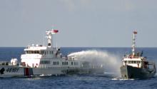 A Chinese coastguard vessel (L) uses water cannon on a Vietnamese Sea Guard ship on the South China Sea near the Paracels islands