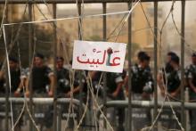 A sign reading, "Go home" is placed on a barbed wire as policemen block a street leading to the parliament building where a session of "national dialogue" is taking place in downtown Beirut, Lebanon, September 9, 2015. PHOTO BY REUTERS/Aziz Taher