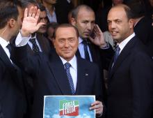 Silvio Berlusconi waves to supporters next to People of Freedom (PDL) Secretary Angelino Alfano (R)