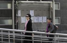 Singer Meng Ge (L) walks into a court ahead of a verdict hearing of her son in Beijing
