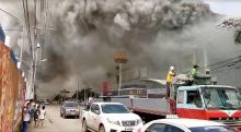 People watch as smoke rises from burning mall's 3rd floor, in Davao City, Philippines, in this December 23, 2017 picture obtained from social media. PHOTO BY REUTERS