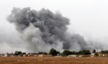 Smoke rises from the Syrian town of Kobani, seen from near the Mursitpinar border crossing on the Turkish-Syrian border in the southeastern town of Suruc in Sanliurfa province