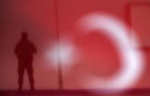 A soldier is seen through a Turkish national flag as he stands guard during an AK Party election rally in Diyarbakir, Turkey, October 29, 2015. PHOTO BY REUTERS/Stoyan Nenov