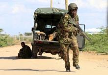 A Kenya Defense Force soldier runs for cover near the perimeter wall where attackers are holding up at a campus in Garissa, April 2, 2015. PHOTO BY REUTERS/Noor Khamis
