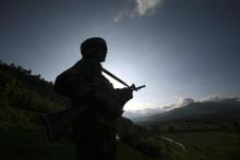 An Indian army soldier stands guard while patrolling near the Line of Control, a ceasefire line dividing Kashmir between India and Pakistan, in Poonch district
