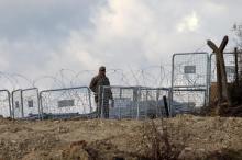 A Turkish soldier standing guard is seen from the Syrian town of Khirbet Al-Joz at the Turkish-Syrian border, in Latakia countryside, where internally displaced Syrian people are waiting to get permission to cross into Turkey, February 7, 2016. PHOTO BY REUTERS/Ammar Abdullah
