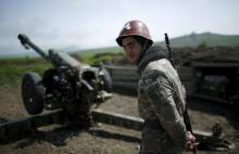 An ethnic Armenian soldier stands next to a cannon at the artillery positions near Nagorno-Karabakh's town of Martuni, April 8, 2016. PHOTO BY REUTERS/Staff