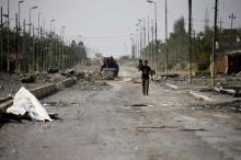 A member of Iraqi counterterrorism forces walks with his weapon. PHOTO BY REUTERS/Thaier Al-Sudani